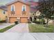 Charming exterior of a two-story townhome with brick driveway, two-car garage and manicured lawn at 5381 Via Appia Way, Sanford, FL 32771