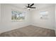 Bedroom with neutral carpeting, two windows, and a modern ceiling fan at 608 S Oxalis Ave, Orlando, FL 32807