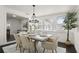 Bright dining room with a modern chandelier, hardwood floors, neutral colors, and multiple windows at 608 S Oxalis Ave, Orlando, FL 32807