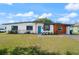 Charming single-story home boasts a well-manicured lawn, inviting blue door, and covered parking at 608 S Oxalis Ave, Orlando, FL 32807