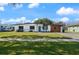 Charming single-story home boasts a well-manicured lawn, inviting blue door, and covered parking at 608 S Oxalis Ave, Orlando, FL 32807
