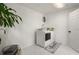 Well-lit laundry room with white marble-style flooring, in-unit washer and dryer, and a storage basket at 608 S Oxalis Ave, Orlando, FL 32807