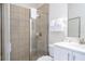 Bright bathroom features a tiled shower with glass doors and a white vanity with a modern sink and faucet at 7600 Mackinaw Ln, Kissimmee, FL 34747