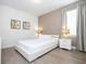 Bright bedroom featuring a platform bed with white bedding and gray hardwood floors at 7600 Mackinaw Ln, Kissimmee, FL 34747
