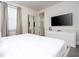Bedroom featuring a queen bed, dresser, TV, and a view to the window at 7600 Mackinaw Ln, Kissimmee, FL 34747