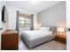 Serene bedroom with a queen-sized bed, soft gray tones, and wood look flooring at 7600 Mackinaw Ln, Kissimmee, FL 34747