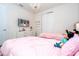 Charming bedroom with a dresser, TV, and two twin beds with pink bedding at 7600 Mackinaw Ln, Kissimmee, FL 34747