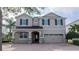 Charming two-story home featuring a brick driveway and a neutral color scheme with black shutters at 7600 Mackinaw Ln, Kissimmee, FL 34747
