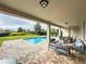 Spacious covered patio with ample seating, offering serene views of the pool and lush backyard at 7600 Mackinaw Ln, Kissimmee, FL 34747