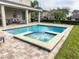 Inviting private pool and spa surrounded by brick pavers, with a manicured lawn and landscaping at 7600 Mackinaw Ln, Kissimmee, FL 34747