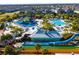 Aerial view of a resort-style water park with a lazy river, water slides, and pools, surrounded by palm trees at 7600 Mackinaw Ln, Kissimmee, FL 34747