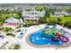 Aerial view of a community water park with slides, pools, and lounging areas in a Gathering friendly neighborhood at 7600 Mackinaw Ln, Kissimmee, FL 34747
