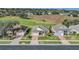 Aerial view of homes next to a golf course featuring mature trees and well-maintained landscaping at 1012 Everest St, Clermont, FL 34711