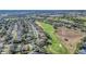 Expansive aerial view of homes lining a golf course with mature trees enhancing the landscape at 1012 Everest St, Clermont, FL 34711