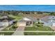 Aerial view of a home with a manicured lawn next to a lush golf course at 1012 Everest St, Clermont, FL 34711