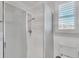 Contemporary bathroom featuring a glass shower, white fixtures, and wainscoting, combining style and functionality at 1012 Everest St, Clermont, FL 34711