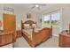 Charming bedroom featuring a wooden bed frame, wood furnishings, and a window offering a view of the neighborhood at 1012 Everest St, Clermont, FL 34711