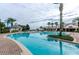 Resort-style community pool with ample seating, surrounded by lush landscaping and palm trees at 1012 Everest St, Clermont, FL 34711