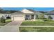 Charming single-story home with a well-maintained lawn, brick driveway, and inviting entryway at 1012 Everest St, Clermont, FL 34711