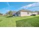 Backyard featuring a screened-in lanai, well-maintained lawn, and beautiful landscaping at 1012 Everest St, Clermont, FL 34711