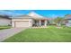 Charming single-story home featuring a manicured lawn, brick pathway, and inviting entryway at 1012 Everest St, Clermont, FL 34711