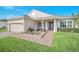 Inviting home with brick pathway, lovely front garden, and a well-maintained lawn at 1012 Everest St, Clermont, FL 34711