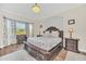 Spacious main bedroom with a large bed, wood floors, and plenty of natural light from the large window at 1012 Everest St, Clermont, FL 34711