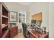 Well-lit home office featuring a wooden desk, shelving, and a window offering natural light and neighborhood views at 1012 Everest St, Clermont, FL 34711
