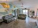 Spacious living room with gray sofas, geometric wall art, and herringbone floors at 124 Hollyhock Ct, Kissimmee, FL 34743