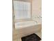 Relaxing bathroom with an oval soaking tub and neutral tile at 124 Lancaster Dr, Davenport, FL 33897
