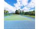Community tennis court with well-maintained surface, surrounded by green fencing and lush landscaping at 124 Lancaster Dr, Davenport, FL 33897
