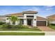 Charming single-story home featuring a tile roof, meticulously landscaped yard, and an attached two-car garage at 13265 Alderley Dr, Orlando, FL 32832