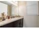 Bathroom with light granite countertops, dark cabinetry, window with blinds and decorative accents at 13596 Gorgona Isle Dr, Windermere, FL 34786