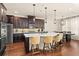 Modern kitchen with dark wood cabinets, stainless steel appliances, and a white countertop island with seating at 13596 Gorgona Isle Dr, Windermere, FL 34786