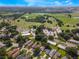 Wide aerial shot displaying the community layout with golf course, pool, tennis courts, and housing at 2214 Se Sawgrass Ct, Winter Haven, FL 33884