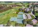 An aerial view showcasing the golf course, swimming pool, and tennis courts within the community at 2214 Se Sawgrass Ct, Winter Haven, FL 33884