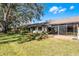 Backyard view of the home featuring a well-maintained lawn and enclosed patio at 2214 Se Sawgrass Ct, Winter Haven, FL 33884