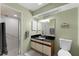 Bathroom with a glass door shower, vanity with black countertop, and decorative wall art at 2214 Se Sawgrass Ct, Winter Haven, FL 33884