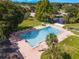 Aerial view of the community pool, featuring lounge chairs, palm trees, and clear blue water at 2214 Se Sawgrass Ct, Winter Haven, FL 33884