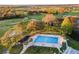 Beautiful swimming pool surrounded by lounge chairs and palm trees, set against the golf course at 2214 Se Sawgrass Ct, Winter Haven, FL 33884
