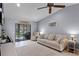 Comfortable living room with neutral tones, a ceiling fan, and sliding glass doors offering plenty of natural light at 2214 Se Sawgrass Ct, Winter Haven, FL 33884