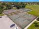 Aerial shot of the community tennis courts with parking and surrounding green spaces at 2214 Se Sawgrass Ct, Winter Haven, FL 33884