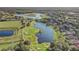 Scenic aerial view of a golf course community with a lake, lush greenery, and beautiful homes at 25974 High Hampton Cir, Sorrento, FL 32776