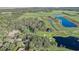 An aerial view displays a beautiful community with a golf course, lakes, and lush greenery at 25974 High Hampton Cir, Sorrento, FL 32776