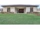 The backyard features sliding glass doors, a lush lawn, and manicured hedges for privacy at 25974 High Hampton Cir, Sorrento, FL 32776
