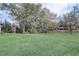 An expansive backyard offers a well-maintained lawn, large trees, and serene, natural surroundings at 25974 High Hampton Cir, Sorrento, FL 32776