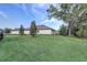 The backyard is expansive with a large lawn, mature trees, and privacy landscaping at 25974 High Hampton Cir, Sorrento, FL 32776