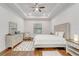 Bright bedroom features hardwood floors, tray ceiling, ceiling fan, and natural lighting at 25974 High Hampton Cir, Sorrento, FL 32776