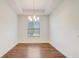 Dining room features hardwood floors, neutral walls, modern chandelier, and bright window at 25974 High Hampton Cir, Sorrento, FL 32776
