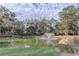 Picturesque pond with a fountain feature, surrounded by lush greenery and trees at 25974 High Hampton Cir, Sorrento, FL 32776